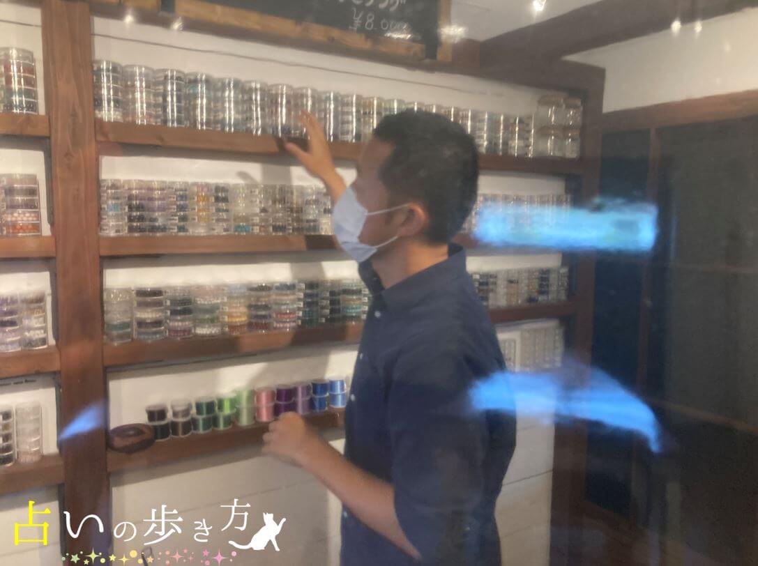 楽氣(ラッキ)先生が店内のパワーストーンを選んでいる様子の画像